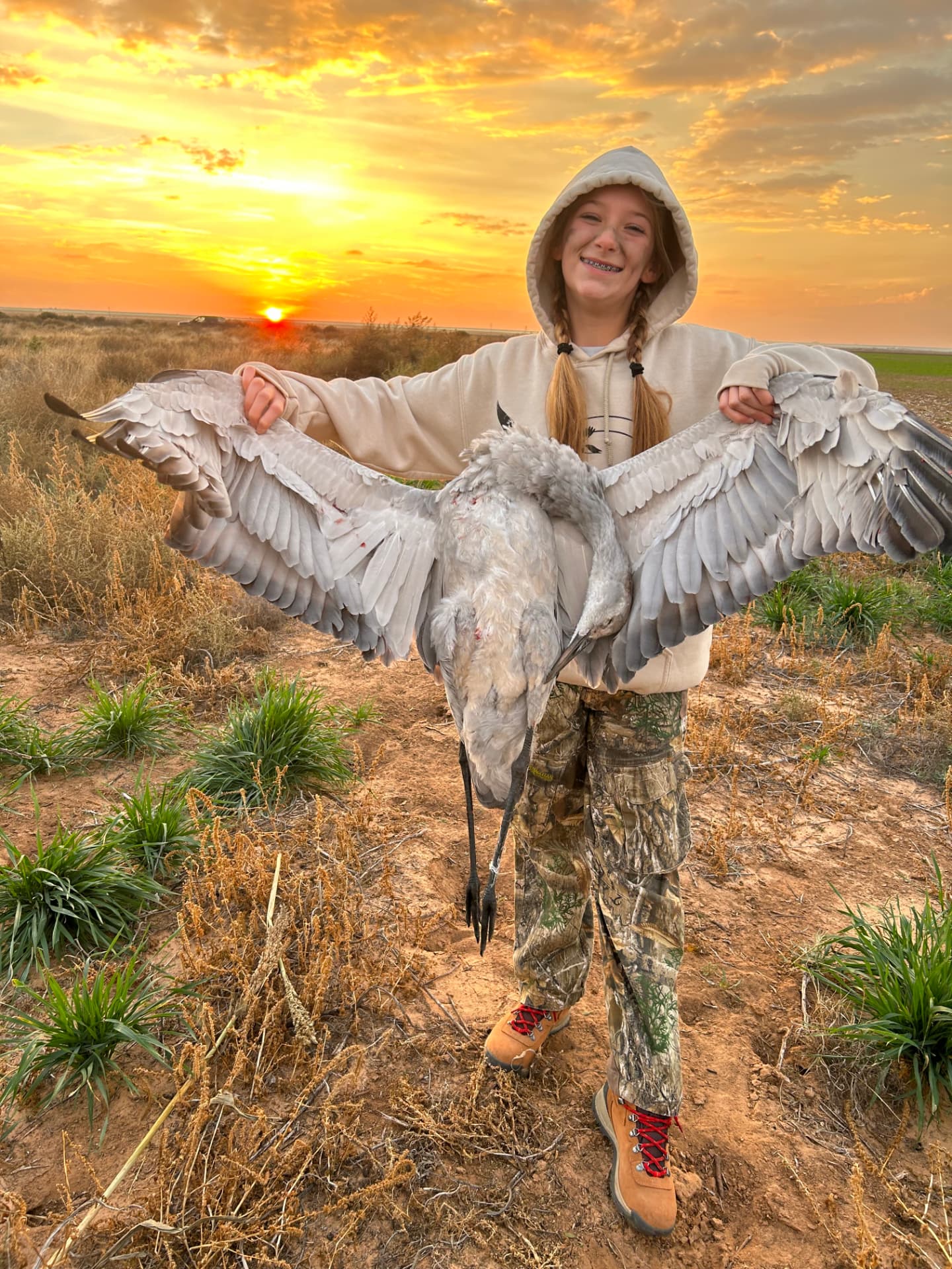 Morgan holding a sandhill crane at sunrise in West Texas